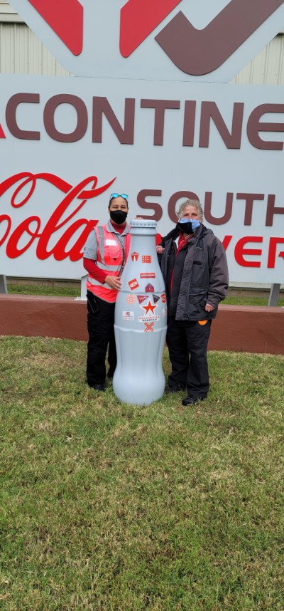 Sophia Sanchez-Fuentez, Warehouse Supervisor, and Max Sura, Transportation Supervisor, with the Recognition Roadtrip Bottle at the Abilene Distribution Center on Nov. 8, 2021.