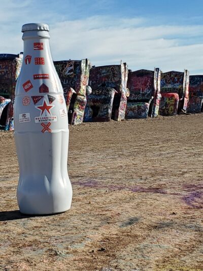The Recognition Roadtrip Bottle posing in front of the famed half-buried Cadillacs. Cadillac Ranch was created in 1974 and later made popular by the Bruce Springsteen 1980 classic album The River where his song “Cadillac Ranch” references the ten buried Cadillacs in Amarillo, Texas.