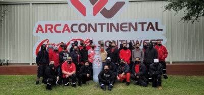 Abilene frontline heroes in front of the Arca Continental CCSWB sign with the Recognition Roadtrip Bottle on Nov. 8, 2021. Arca Continental, the parent company of Coca-Cola Southwest Beverages, is excited to celebrate the 5-year anniversary of CCSWB.
