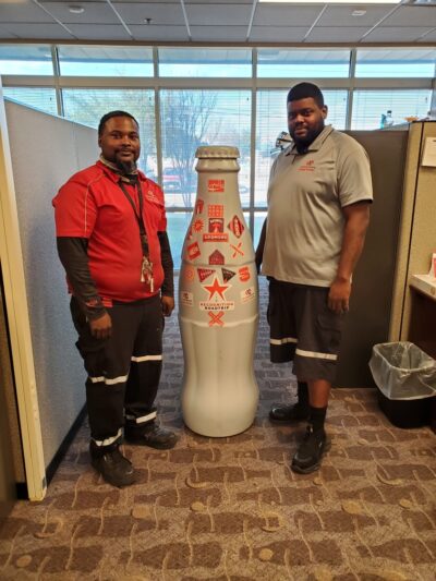 Gary Chambers and Broderick Lowe, Delivery Merchandisers, with the bottle in the Waco facility on Dec. 21, 2021.
