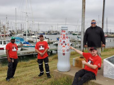 El Campo heroes with the Recognition Roadtrip Bottle at Tres Palacios Bay on Jan. 6, 2022. Thirty miles away from El Campo, Tres Palacios Bay feeds into the Gulf of Mexico.