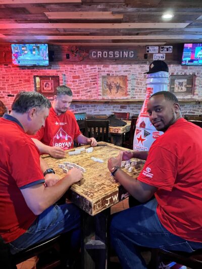 Bryan heroes play dominos with the Recognition Roadtrip Bottle in Dixie Chicken on Jan. 12, 2022. Dixie Chicken, also known as “The Chicken,” was opened in College Station in 1974, and it’s not uncommon to see people playing dominoes there or anywhere else in the city!