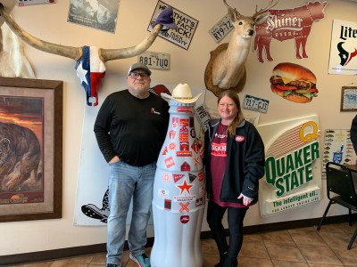 The Recognition Roadtrip Bottle gets the full VIP treatment at Nacburger in Nacogdoches on Jan. 20, 2022. NacBurger owner, Billie Huddleston, shows the bottle and Kacy Murdock, CCSWB Market Development Manager (FSOP), around his beloved family-owned burger joint!
