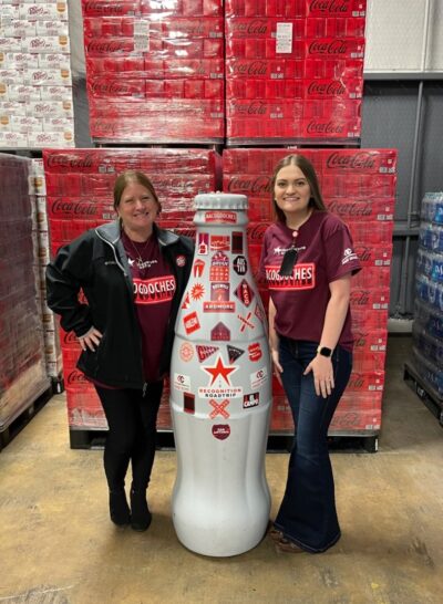 Nacogdoches heroes Kacy Murdock, Market Development Manager (FSOP), and Jordan Noland, Route Process Administrator, show the Recognition Roadtrip Bottle around the Nacogdoches facility on Jan. 20, 2022.
