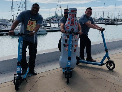 The Recognition Roadtrip Bottle goes for a spin along the water’s edge with Blue Duck scooters on March 14, 2022.