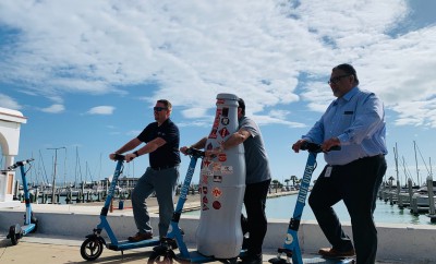 Balancing act…Corpus Christi heroes and the Recognition Roadtrip Bottle take a ride with Blue Duck scooters on March 14, 2022. The scooters offer visitors and locals a chance to zip around downtown Corpus and see the sights, and during COVID, served as an individual, social-distance-friendly form of transportation.