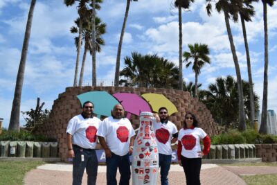 McAllen heroes with the Recognition Roadtrip Bottle on South Padre Island on March 9, 2022.