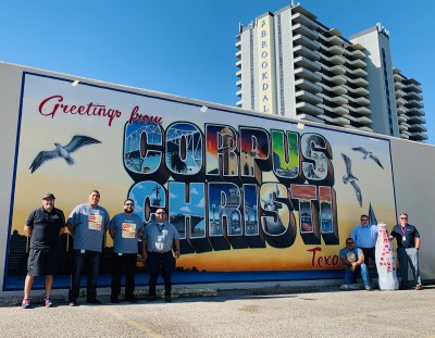 CCSWB heroes welcome the Recognition Roadtrip Bottle to Corpus Christi, Texas at the Greetings mural downtown on March 14, 2022. The mural, designed in 2018 by local artist Jeremy Flores, was a gift to the city by IT services company, Richline Technical Services. The mural was inspired by a Richline executive’s trip to Valparaiso, Chile, a beautiful coastline city covered with murals.