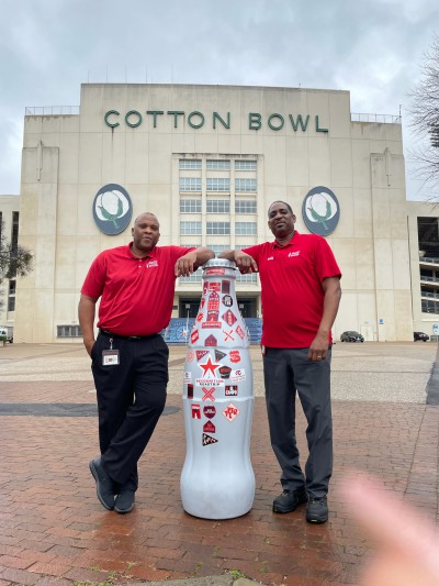 Mesquite heroes Dwayne Packer, Sales Center Manager, and Cardell Armstrong, Warehouse Manager, with the Recognition Roadtrip Bottle at the Cotton Bowl on Feb. 21, 2022.