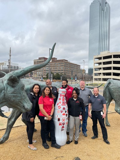 Mesquite heroes take the Recognition Roadtrip Bottle on a stroll through the Pioneer Plaza in Downtown Dallas on Feb. 21, 2022. The bronze cattle were created by Texas artist Robert Summers nearly 30 years ago to honor the cattle drivers who traveled through Dallas on the Shawnee Trail in the mid-1800s.