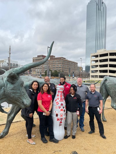 Mesquite heroes take the Recognition Roadtrip Bottle on a stroll through the Pioneer Plaza in Downtown Dallas on Feb. 21, 2022. The bronze cattle were created by Texas artist Robert Summers nearly 30 years ago to honor the cattle drivers who traveled through Dallas on the Shawnee Trail in the mid-1800s.