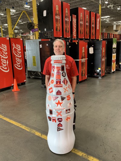 EFC hero, Roy Butler, Technician, take a peek from behind the Recognition Roadtrip Bottle on Feb. 22, 2022.