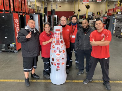 EFC heroes with the Recognition Roadtrip Bottle on Feb. 22, 2022. With skills ranging from refrigeration repair to painting and working with vendors, the EFC team members all work together to repair as many as 1,150 pieces of equipment a month.