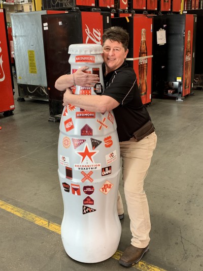 EFC hero, Toni Russell, Warehouse Supervisor, hugs the Recognition Roadtrip Bottle on Feb. 22, 2022.