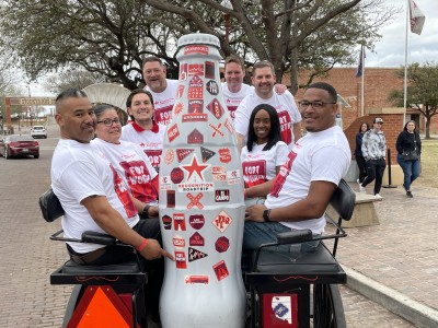 Fort Worth heroes with the Recognition Roadtrip Bottle on a carriage ride through the Fort Worth Stockyards on March 22, 2022. In 1976, nearly thirty years after the decline of the Stockyards, the North Fort Worth Historical Society was founded to help restore key landmarks and traditions from the past. Today, the Stockyards has become one of the most popular tourist destinations in Texas.