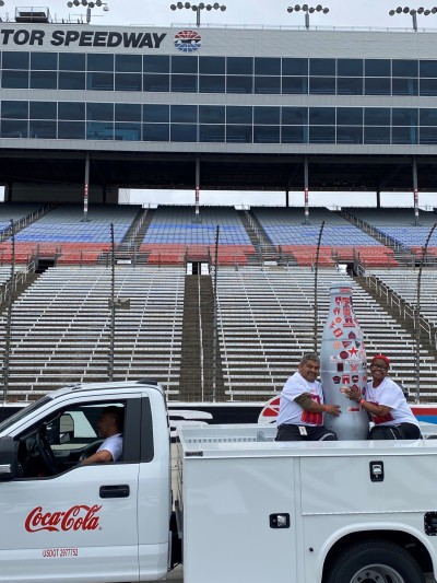 “Ladies, Gentlemen and, ahem, Bottles…Start your engines!” Fort Worth heroes prepare the Recognition Roadtrip Bottle in front of the grandstands for a race around Texas Motor Speedway on March 22, 2022. The front grandstand is constructed of 15,000 tons of steel and 2 million pounds of aluminum – enough to produce 61 million Coca-Cola cans!