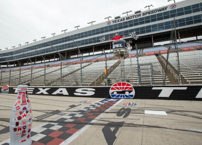 “And the winner of the Recognition Roadtrip Race is…” The Recognition Roadtrip Bottle crosses the finish line of Texas Motor Speedway as Greg Artkop, Director of Communications, waves the checkered flags to signify the end of the race.