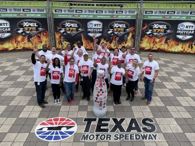 Everyone is a winner at CCSWB! Fort Worth heroes celebrate with the Recognition Roadtrip Bottle in Victory Lane at Texas Motor Speedway on March 22, 2022. Victory Lane marks the space where race winners celebrate a successful day by donning (what else?) cowboy hats surrounded by artificial flames and cheering fans.