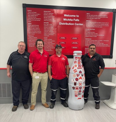 The Wichita Falls Cooler Service heroes pose with the Recognition Roadtrip Bottle at their distribution center on March 28, 2022. This distribution center has provided Coca-Cola brands to the Wichita Falls community for over a century!