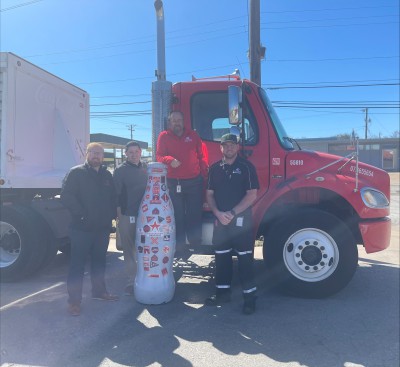 Taking the driver’s seat? The local Wichita Falls drivers pose with the Recognition Roadtrip Bottle and a Coca-Cola truck at their facility on March 28, 2022