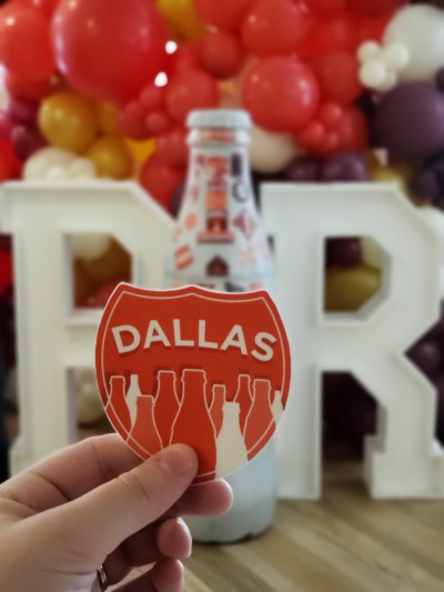 Dallas heroes prepare to put the city sticker on the Recognition Roadtrip Bottle on April 1, 2022. The team marked the anniversary celebration with special balloons and “Recognition Roadtrip” block initials for team members and the Bottle to strike a pose!